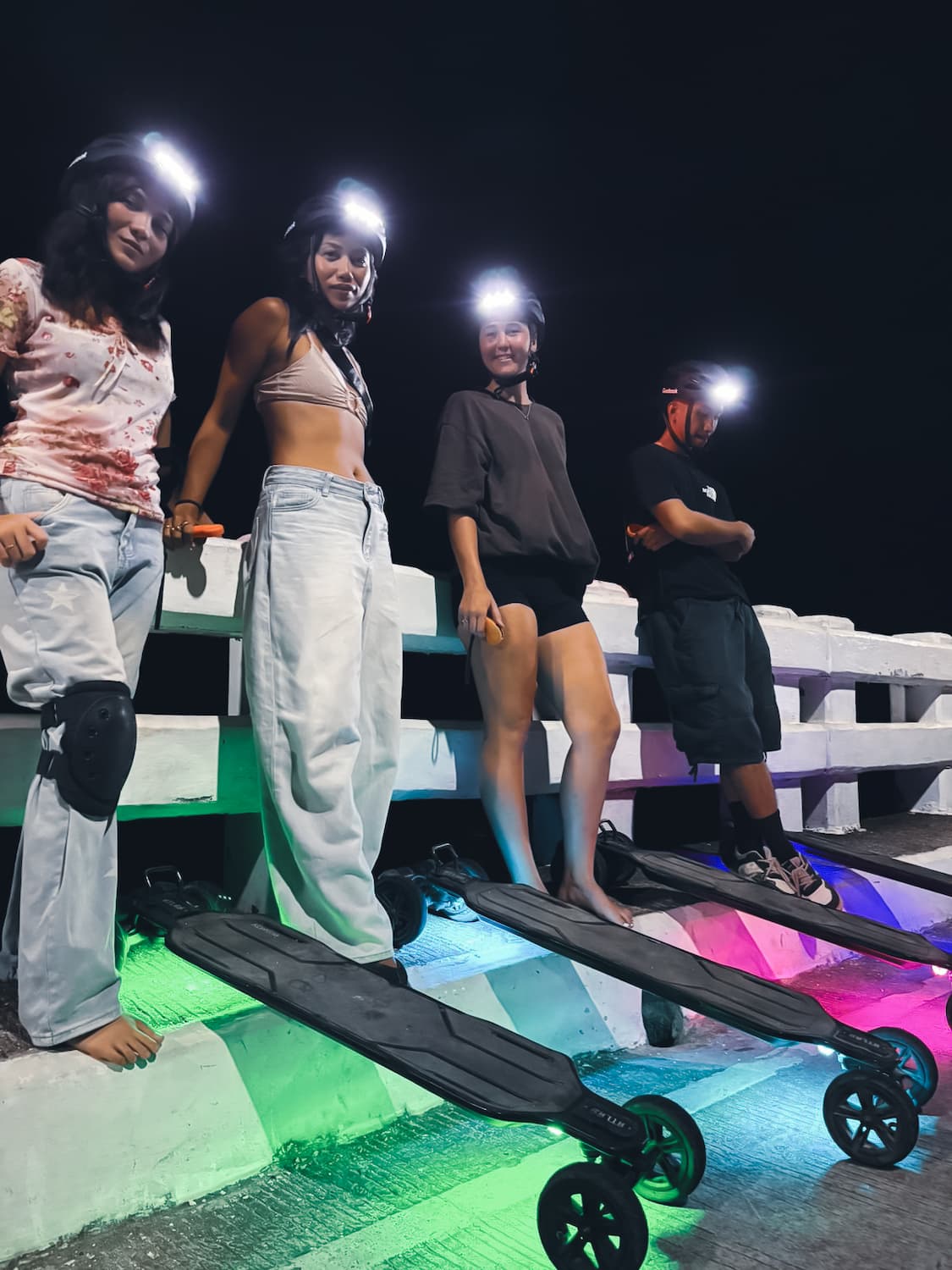 Group riding LED-lit electric skateboards on the night tour in Siargao