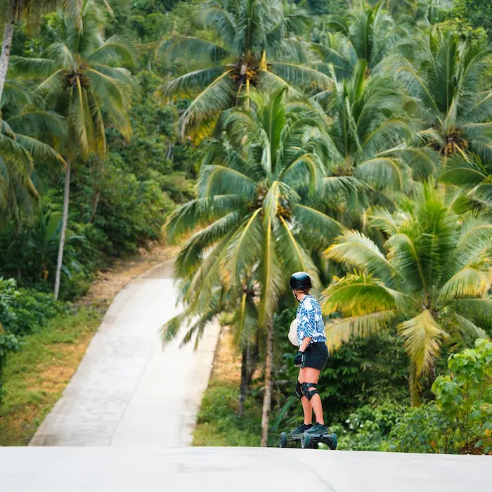Rider on palm-lined road, Siargao eSk8 tour